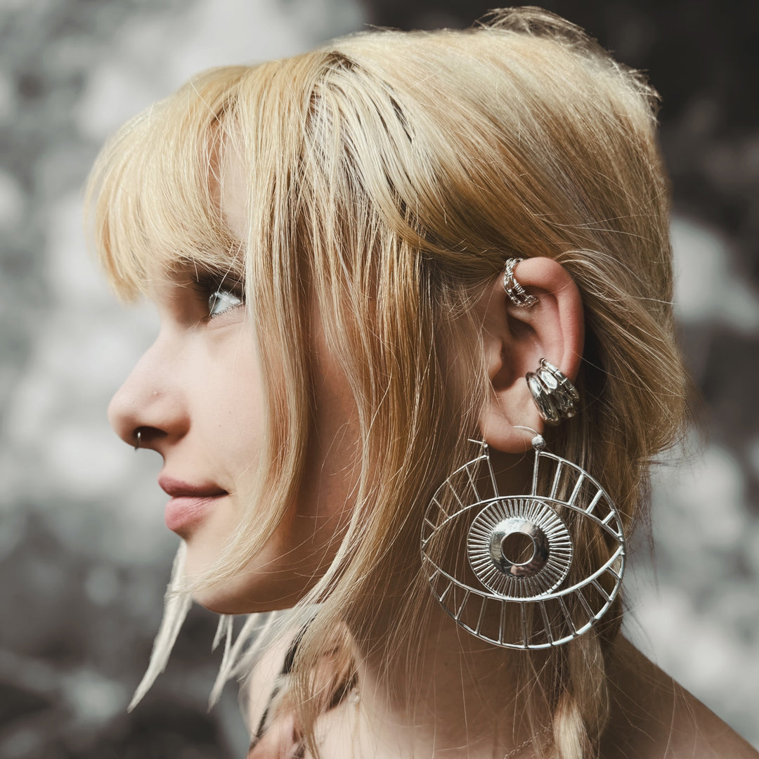 Geometric cutout hoop earrings with surreal eye detailing
